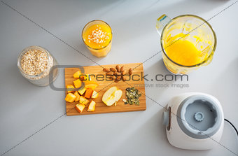 Close-up on pumpkin smoothie and ingredients on table
