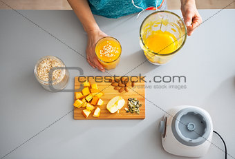 Fitness young woman making pumpkin smoothie