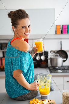 Portrait of happy fitness young woman with glass of pumpkin smoo