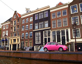 pink car on a canal in Amsterdam, Netherlands