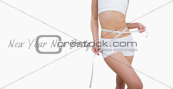 Midsection of slim woman measuring waist
