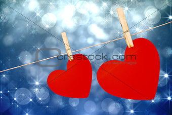 Composite image of hearts hanging on a line