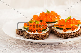 Heart shaped toasts  with red caviar and white wine