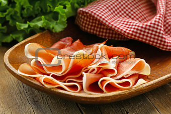 parma ham (jamon) sliced on a wooden board