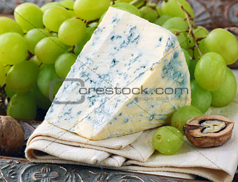 piece of blue cheese with fruits and herbs