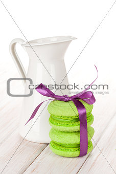 Green macarons with purple ribbon and milk jug