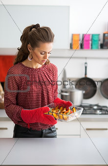 Young housewife holding baked pumpkin