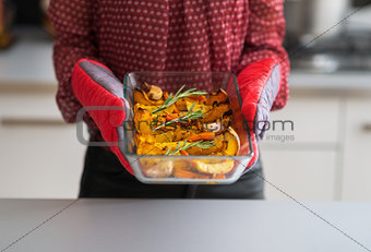 Closeup on young housewife holding baked pumpkin