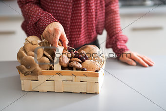 Closeup on young housewife with basket with mushrooms