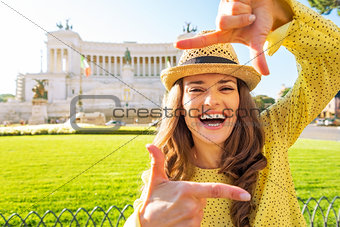 Happy young woman framing on piazza venezia in rome, italy
