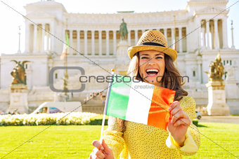 Portrait of happy young woman showing italian flag on piazza ven