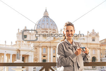 Smiling young woman with photo camera on piazza san pietro in va