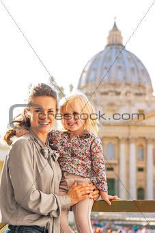 Portrait of happy mother and baby girl in front of basilica di s