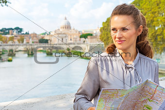 Happy young woman with map on bridge ponte umberto I with view o