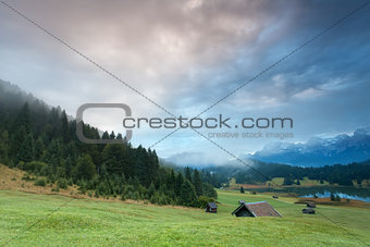 misty sunrise over alpine meadows by Geroldsee lake