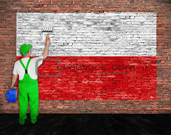 House painter paints flag of Poland on brick wall