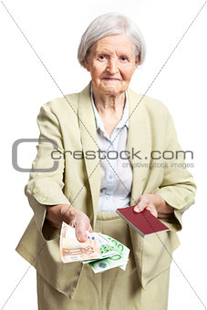 Senior woman giving money and holding passport, hand with money in focus. Isolated over white