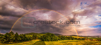 Rainbow over Landscape at Sunset
