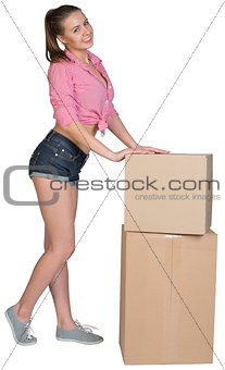 Woman leaning on stacked cardboard boxes