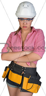 Woman in hard hat, protective glasses and tool belt