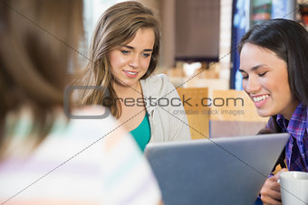 Young students doing assignment on laptop together