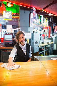 Pretty barmaid wiping down bar