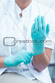 Mid section of dentist wearing surgical glove