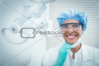 Female dentist wearing surgical cap and safety glasses
