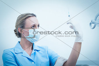 Female dentist holding injection