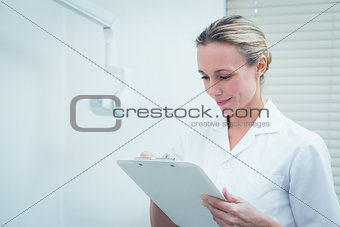 Female dentist checking reports