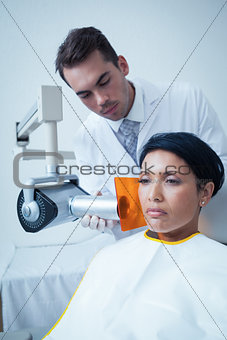 Serious young woman undergoing dental checkup