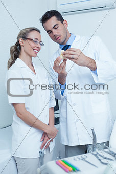 Dentists looking at mouth model