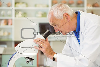 Senior scientist looking through microscope