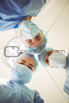 Young surgeons looking down at camera