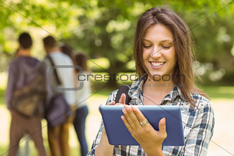 Portrait of a smiling student with a shoulder bag and using tablet computer
