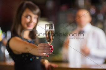 Pretty brunette smiling at camera with champagne