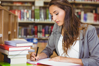 Concentrating brunette student doing her assignment
