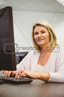 Mature student using laptop looking at camera