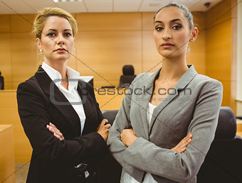 Two serious lawyers standing with arms crossed