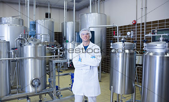 Scientist with arms crossed standing in front of container