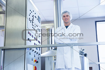 Smiling scientist standing with arms crossed