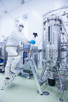 Scientist in protective suit climbing on ladder