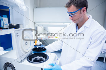 Chemist wearing safety glasses and using a centrifuge