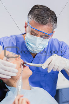 Dentist wearing surgical mask and safety glasses