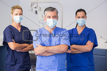 Co-workers wearing surgical mask with arms crossed