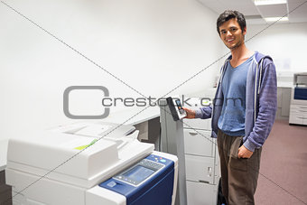Smiling student standing next to the photocopier