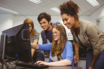 Cheerful student pointing at computer