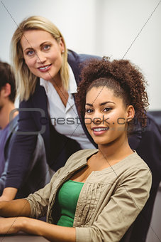 Cheerful teacher and student looking at camera
