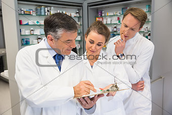Team of pharmacists looking at clipboard