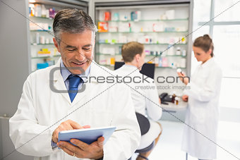 Senior pharmacist using tablet pc